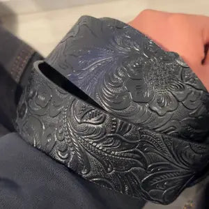 Boho-style faux leather Western-textured cowboy belt featuring a cross buckle and Gothic flair; a unisex accessory suitable for pairing with jeans and casual wear.